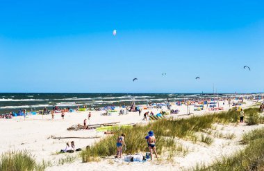 LEBA, POLAND - 14 AĞUSTOS 2015: Leba sahillerinde eğlenen insanlar, güzel hava, mavi yaz gökyüzü, Baltık denizi, Polonya.