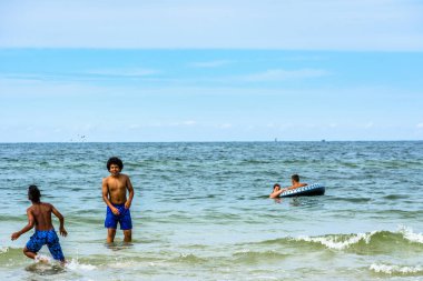 LEBA, POLAND - 31 HAZİRAN 2016: Baltık Denizi üzerinde yaz tatilinde, denizde oynayan siyahi çocuklar