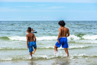 LEBA, POLAND - 31 HAZİRAN 2016: Baltık Denizi üzerinde yaz tatilinde, denizde oynayan siyahi çocuklar
