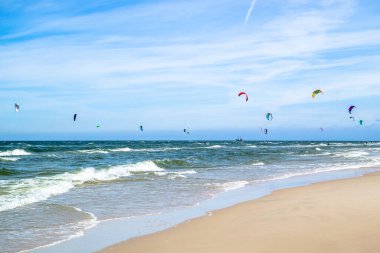 LEBA, POLAND - 09 Temmuz 2016: Polonya 'daki Leba plajında uçurtmacılar. Polonya deniz kıyıları uçurtma uçurmak gibi aşırı su sporları için popüler bir yerdir..