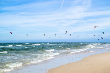 LEBA, POLAND - 09 Temmuz 2016: Polonya 'daki Leba plajında uçurtmacılar. Polonya deniz kıyıları uçurtma uçurmak gibi aşırı su sporları için popüler bir yerdir..
