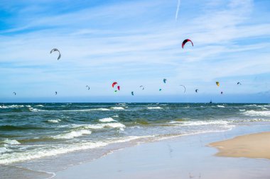 LEBA, POLAND - 09 Temmuz 2016: Polonya 'daki Leba plajında uçurtmacılar. Polonya deniz kıyıları uçurtma uçurmak gibi aşırı su sporları için popüler bir yerdir..