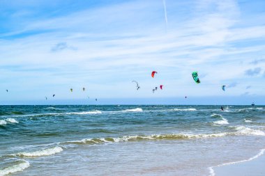 LEBA, POLAND - 09 Temmuz 2016: Polonya 'daki Leba plajında uçurtmacılar. Polonya deniz kıyıları uçurtma uçurmak gibi aşırı su sporları için popüler bir yerdir..