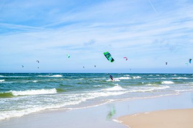LEBA, POLAND - 09 Temmuz 2016: Polonya 'daki Leba plajında uçurtmacılar. Polonya deniz kıyıları uçurtma uçurmak gibi aşırı su sporları için popüler bir yerdir..