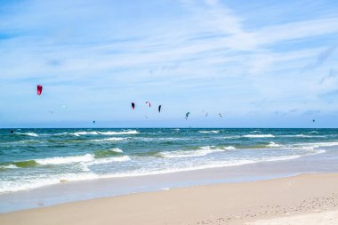 LEBA, POLAND - 09 Temmuz 2016: Polonya 'daki Leba plajında uçurtmacılar. Polonya deniz kıyıları uçurtma uçurmak gibi aşırı su sporları için popüler bir yerdir..