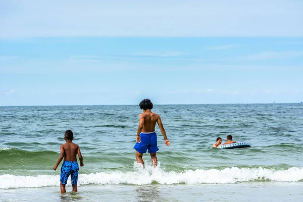 LEBA, POLAND - 31 HAZİRAN 2016: Baltık Denizi üzerinde yaz tatilinde, denizde oynayan siyahi çocuklar