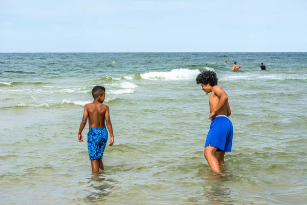 LEBA, POLAND - 31 HAZİRAN 2016: Baltık Denizi üzerinde yaz tatilinde, denizde oynayan siyahi çocuklar
