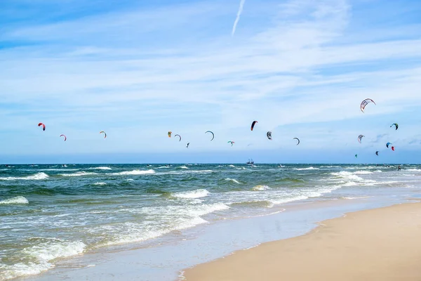 LEBA, POLAND - 09 Temmuz 2016: Polonya 'daki Leba plajında uçurtmacılar. Polonya deniz kıyıları uçurtma uçurmak gibi aşırı su sporları için popüler bir yerdir..