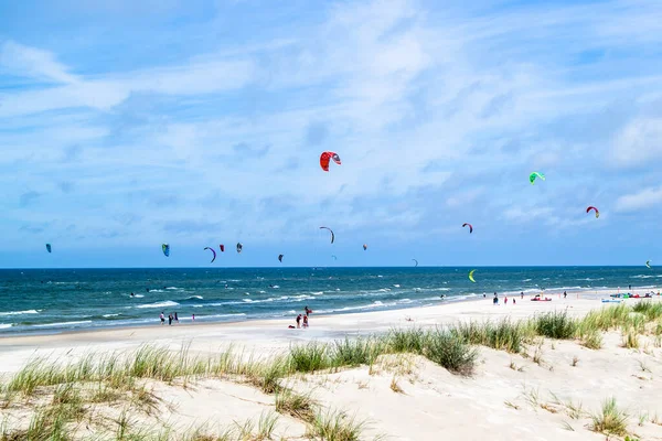 LEBA, POLAND - 09 Temmuz 2016: Polonya 'daki Leba plajında uçurtmacılar. Polonya deniz kıyıları uçurtma sörfü gibi aşırı su sporları için popüler bir yerdir..