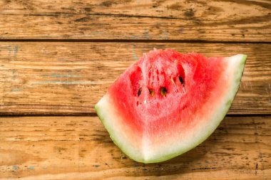 Eski ahşap arka planda bir dilim karpuz.