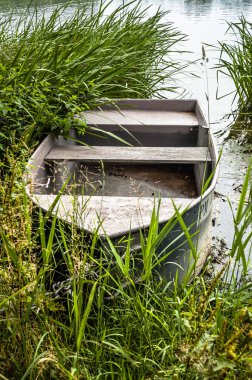 Kıyıdaki gölde sazlıkların arasında balık tutmak için bir tekne. Açık hava düğün teması. Tatil, tatil, eğlence ve ilişki teması.