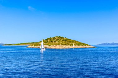 Hırvatistan kıyıları, deniz ve gökyüzü. Küçük ada ve deniz yatı, Hırvatistan, tatil seyahati konsepti.