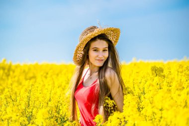 Baharda çiçek açan kolza tohumu tarlasında genç bir kadın.
