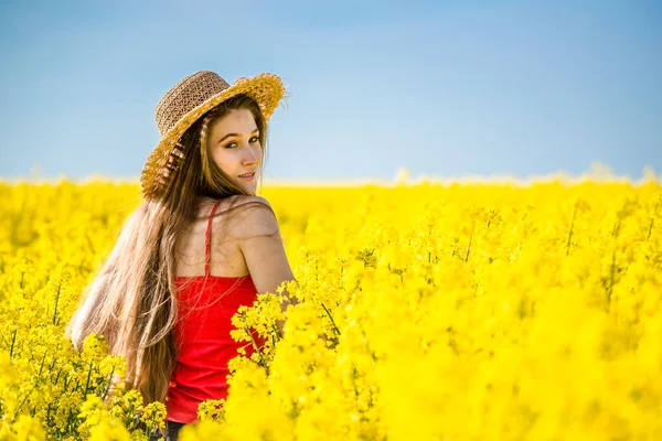Baharda çiçek açan kolza tohumu tarlasında genç bir kadın.