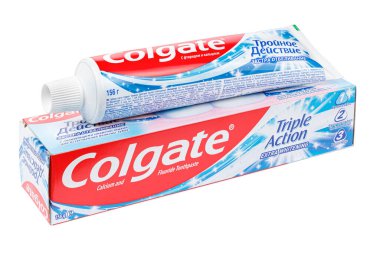 Moskova, Rusya - 27 Mart 2021: Colgate Üçlü Eylem başlıklı karton ambalaj ve tüp beyaz zemin üzerinde izole edilmiş kalsiyum ve florür içeren ekstra beyazlatıcı diş macunu