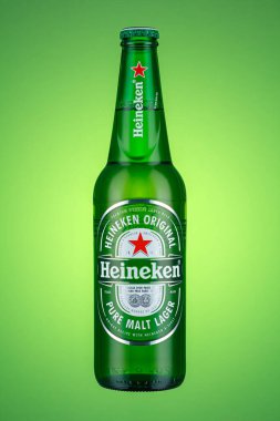 Moskova, Rusya - 07 Nisan 2021: Heineken 'in şeffaf etiketli yeşil cam şişe yeşil arka planda saf malt birası