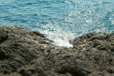 Taş uçurumlar ve deniz. Güzel deniz manzarası. Denizci geçmişi. Denizde tatil. Güneşli yaz günü.