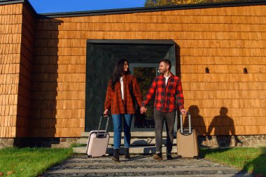 Yakışıklı sakallı bir adam ve güzel bir kadın bavullarıyla dışarı çıkar ve geziye çıkarlar..