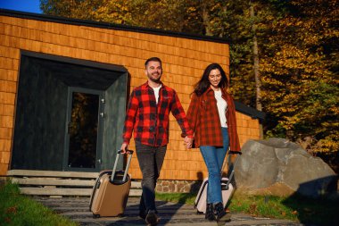 Yakışıklı sakallı bir adam ve güzel bir kadın bavullarıyla dışarı çıkar ve geziye çıkarlar..