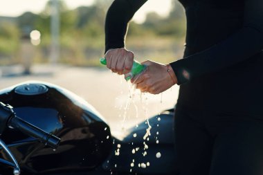 Kadın eli sıkarken spor motosikletini oto yıkamada silerken bez parçasından nem çıkıyor..