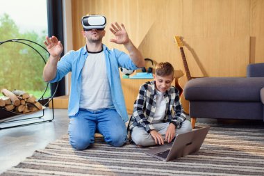Heyecanlı baba-oğul sanal gerçeklik kulaklığını test ederek arttırılmış gerçeklik oyunları oynuyorlar..