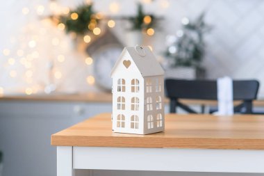 Hoş, küçük dekoratif bir ev, rahat Noel ışıklarının arka planında. Kış tatili kavramı.