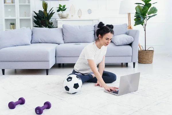 Happy mom on the floor at home with kids and watch funny cartoon on laptop.