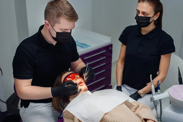 Modern moda kliniğinde dişçi koltuğunda kırmızı gözlüklü güzel bir kadın hasta.. — Stok fotoğraf