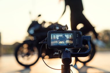 Genç bir kadın oto yıkamada motosikleti yüksek basınçlı suyla yıkıyor..