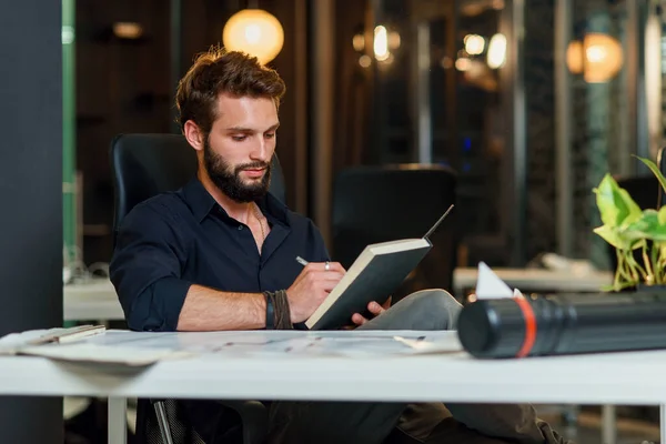 Young bearded architect working with scratches on his new project. — Stock Photo, Image