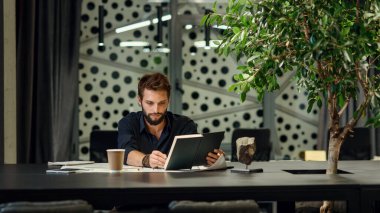 Genç sakallı mimar yeni projesinde çiziklerle çalışıyor..