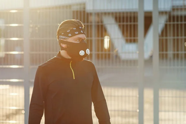 Healthy and handsome young man running at the cityspace. The man wearing a respirator for cardio training. — Stock Photo, Image