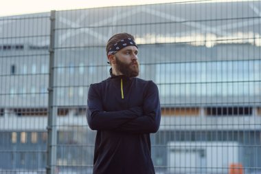 Spor üniformalı ve bandanalı erkek sakallı sporcu çocuk parkında sıkı çalıştıktan sonra.