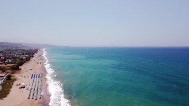 Bir İHA gün doğumunda Ege Denizi sahilinde adanın üzerinde uçar..