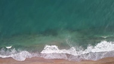 Güzel tropikal kumsalın insansız hava aracı görüntüsü. Güzel, temiz kum ve denizde turkuaz dalgalar..