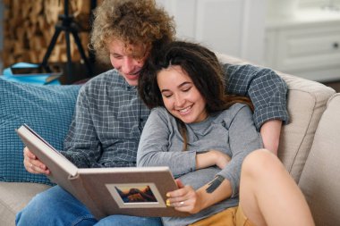 Hamile bir çift bebek bekliyor ve aile fotoğraflarına bakıyorlar..