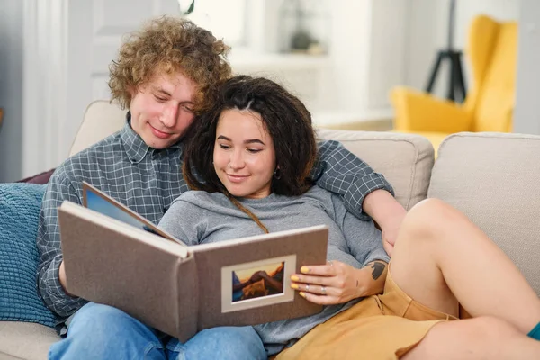 Pasangan muda hamil mengharapkan bayi dan melihat buku foto keluarga mereka. — Stok Foto
