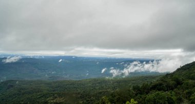 Tepenin tepesinde sisli ve bulutlu bir gökyüzü