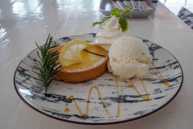Limonlu turta, vanilyalı dondurma, kafede yuvarlak bir tabakta.