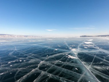 Kış mevsiminde güneşli mavi gökyüzü ile donuk Baykal Gölü 'nde çatlaklar