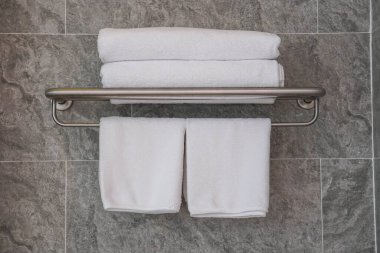 Banyodaki korkuluklara temiz beyaz pamuk havlular.