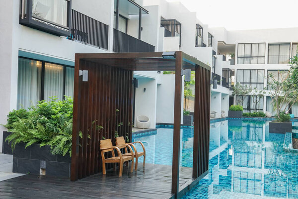 Хуахин Таиланд - 21 февраля 2021 года: два деревянных кресла у бассейна для размещения в роскошном отеле