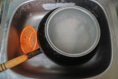 Yemek yaptıktan sonra temizlik için mutfak lavabosunda seçici odak kirli tavası