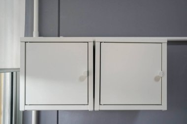 Evin oturma odasında asılı beyaz, en az çelik olan raf kutusu.