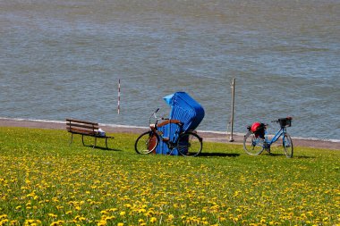 Bikes and beach chair at the North Sea coast clipart