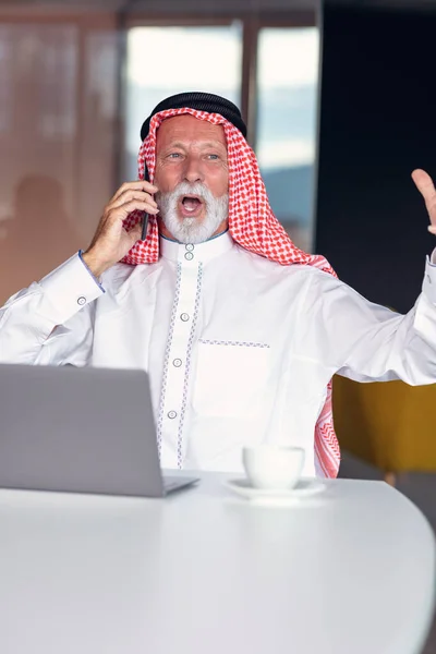 Empresario árabe confiado y sonriente en la oficina usando laptop. — Foto de Stock