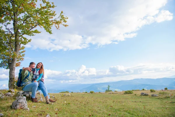 Par som sitter på en klippa och vilar under vandringen och tar selfie — Stockfoto