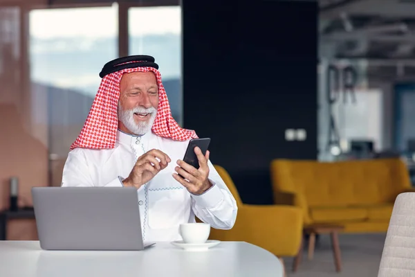 Arabský podnikatel sebevědomý a usmívající se v kanceláři pomocí notebooku. — Stock fotografie