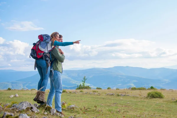 Deux randonneurs avec sac à dos debout au sommet d'une montagne et regarder — Photo
