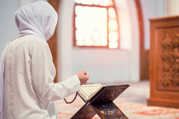 Wanita muslim muda membaca Quran di masjid dan sinar matahari jatuh dari jendela — Stok Foto